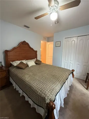 Bedroom with carpet, ceiling fan, and a closet