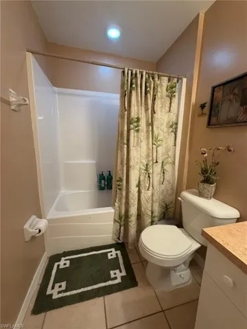 Bathroom featuring vanity, shower / tub combo with curtain, light tile patterned flooring, and recessed lighting