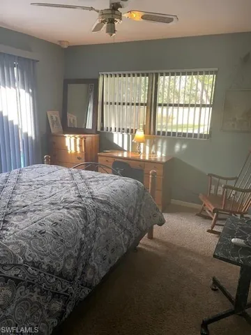 Bedroom with carpet, ceiling fan, and multiple windows