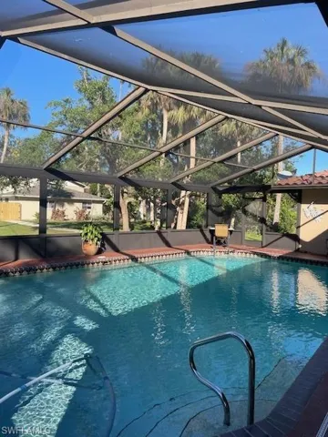 View of swimming pool with screened enclosure