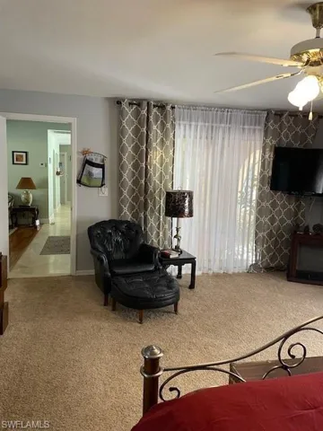 Carpeted bedroom featuring ceiling fan