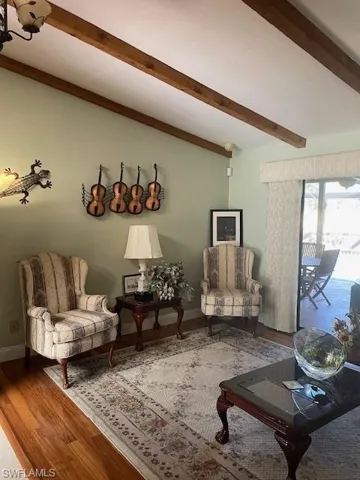 Living room featuring beam ceiling and wood-type flooring