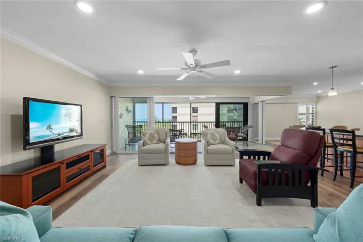 Open-concept living area featuring a neutral color palette, recessed lighting, and crown molding
