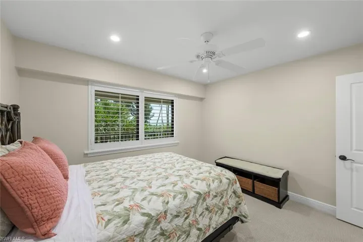 Recessed lighting, ceiling fan, and window with plantation shutters