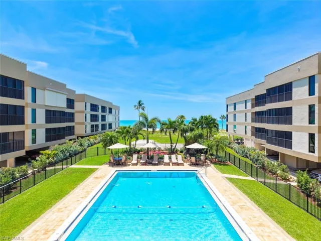 Rectangular swimming pool surrounded by a paver deck and manicured lawn