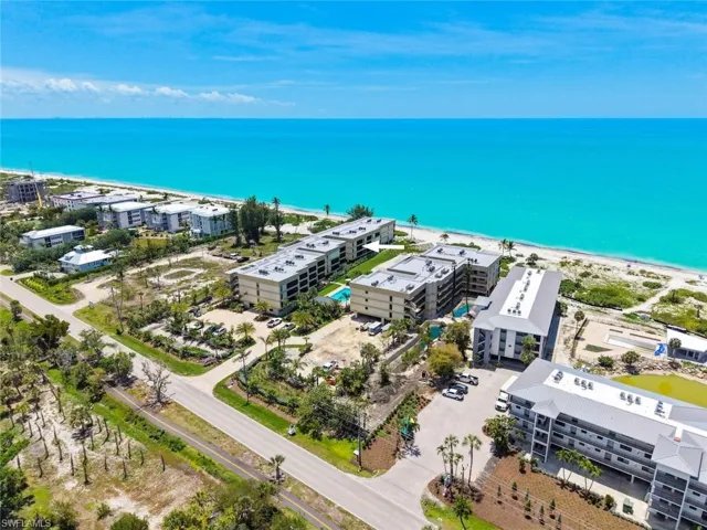 Coastal condominium community featuring direct beach access, multiple multi-story buildings, and a private swimming pool