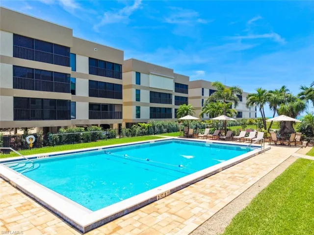 Outdoor swimming pool with integrated steps, surrounded by a paver patio and green lawn