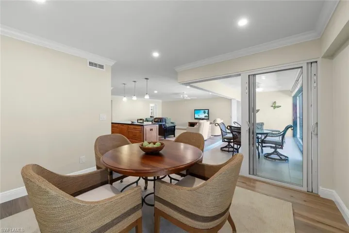 Dining area featuring crown molding, recessed lighting, and wood-finish flooring