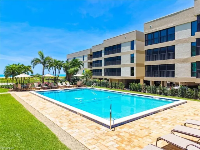 Rectangular outdoor pool featuring a light blue interior and white coping, surrounded by a paver patio