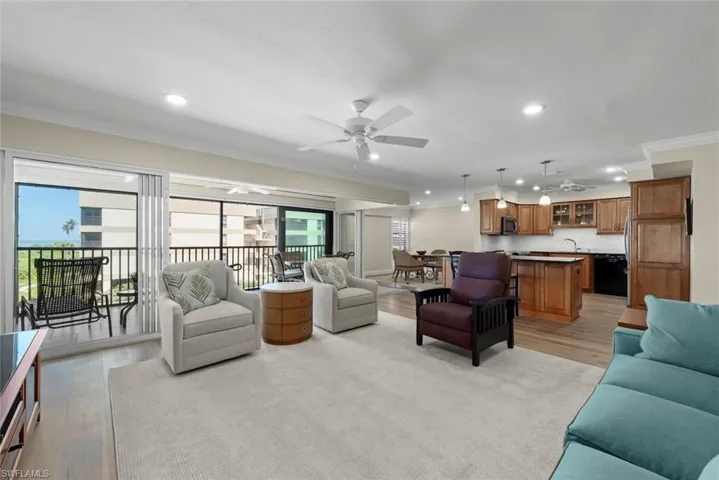 Open-concept living space featuring wood-finish flooring, recessed lighting, and a private balcony with water scenery