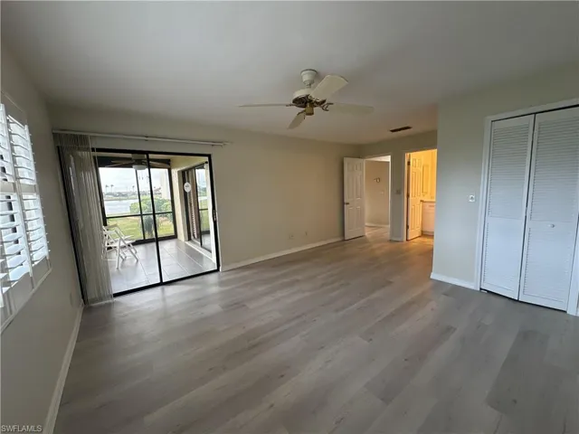Unfurnished bedroom with access to outside, ceiling fan, a closet, and light hardwood / wood-style floors