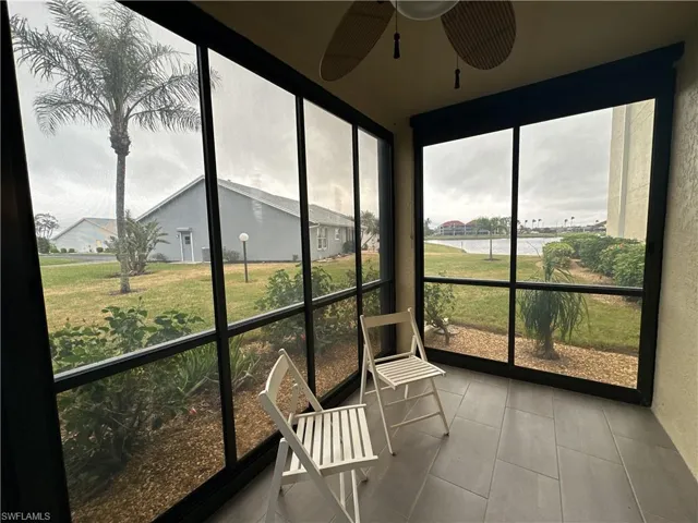 Sunroom / solarium with a water view, ceiling fan, and plenty of natural light