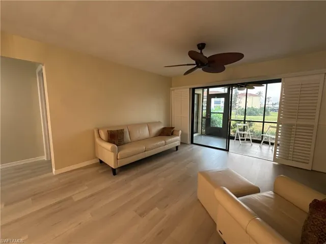 Living room with light wood-type flooring and ceiling fan