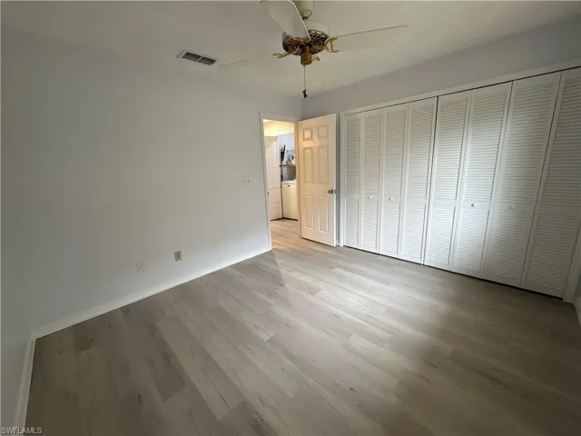 Unfurnished bedroom featuring ceiling fan, a closet, light hardwood / wood-style floors, and washer / clothes dryer