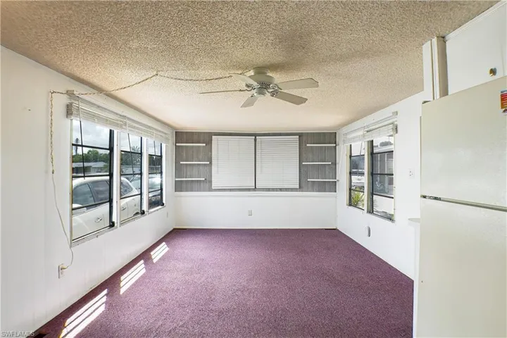 Unfurnished sunroom featuring a healthy amount of sunlight and ceiling fan