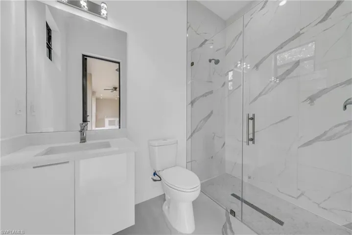Full bath with a marble finish shower and vanity