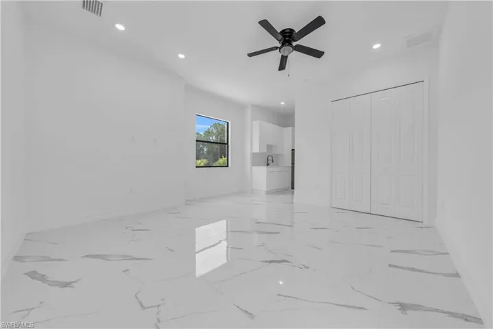 Unfurnished bedroom with recessed lighting, light marble finish flooring, a ceiling fan, and a closet