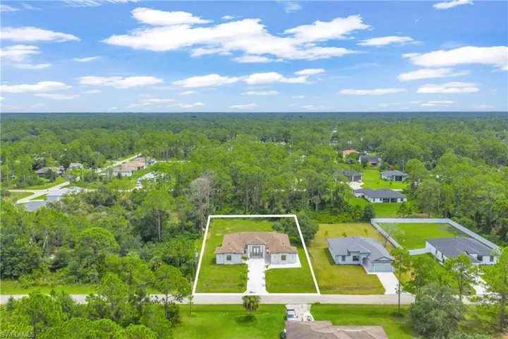 Aerial view of residential area featuring a forest and property parcel outlined