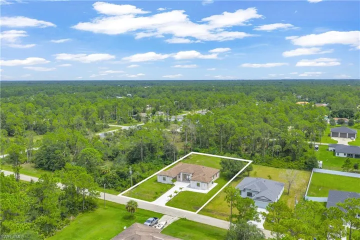 Aerial perspective of suburban area with a forest and property boundaries highlighted