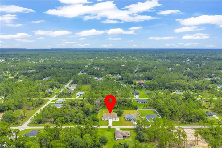 Aerial perspective of suburban area featuring a heavily wooded area