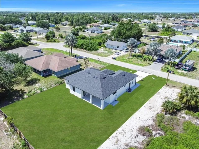New construction home featuring a dark shingle roof, white exterior siding, and a covered patio