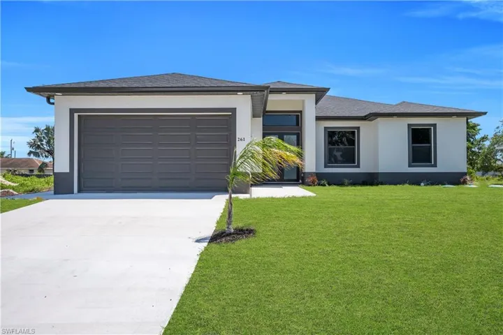 Modern exterior featuring a two-car garage, concrete driveway, and a well-maintained lawn
