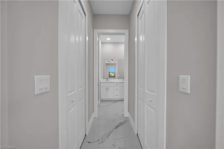 Hallway with neutral wall tones and white bi-fold closet doors