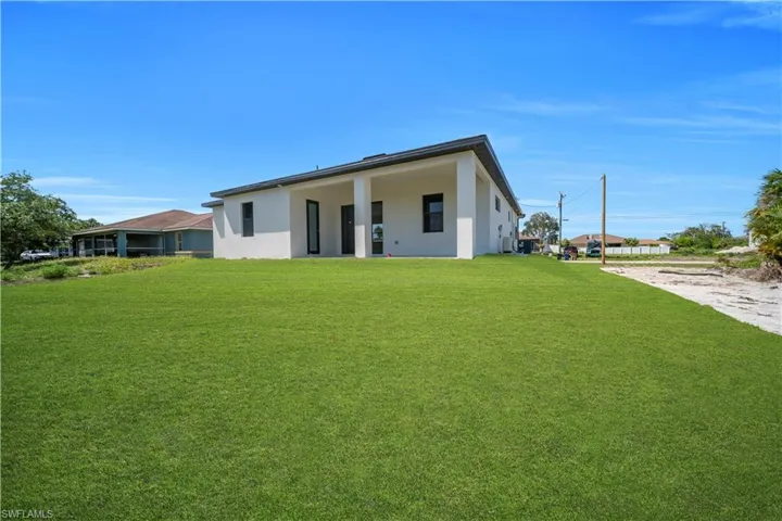 Expansive green lawn surrounds a contemporary residence with a flat roofline