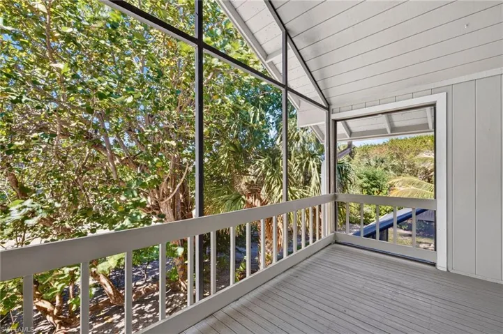 Screened-in balcony featuring a vaulted ceiling, tongue-and-groove paneling, wood-finish flooring, and painted railings