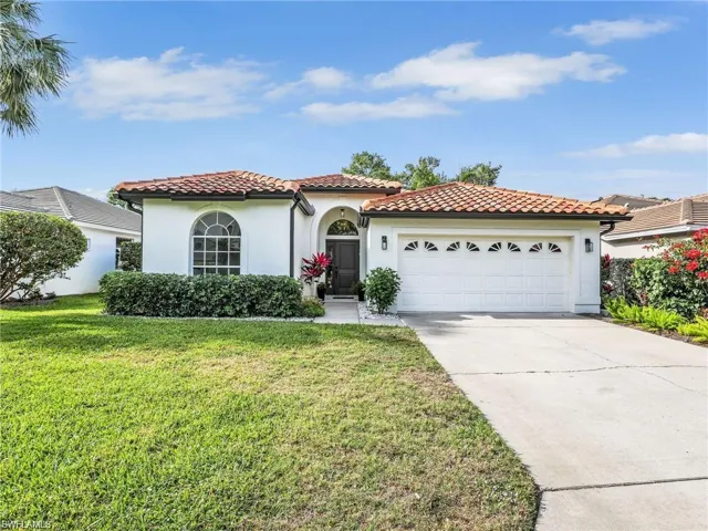 Mediterranean / spanish-style home with stucco siding, concrete driveway, a front yard, a tile roof, and an attached garage