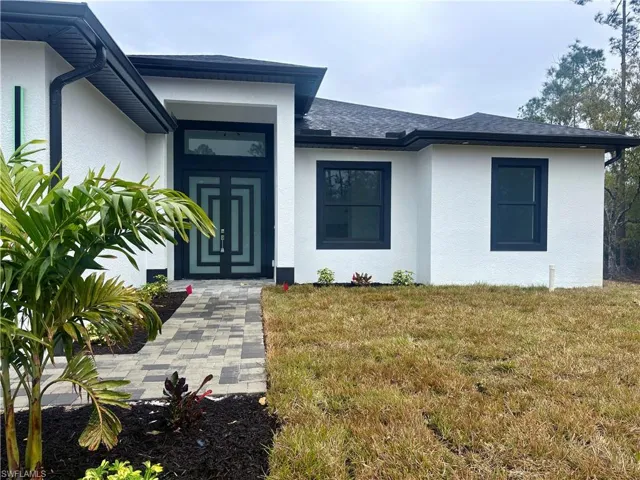 Doorway to property featuring a lawn