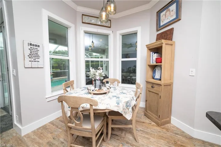 Dining room featuring light wood finished floors, baseboards, and crown molding