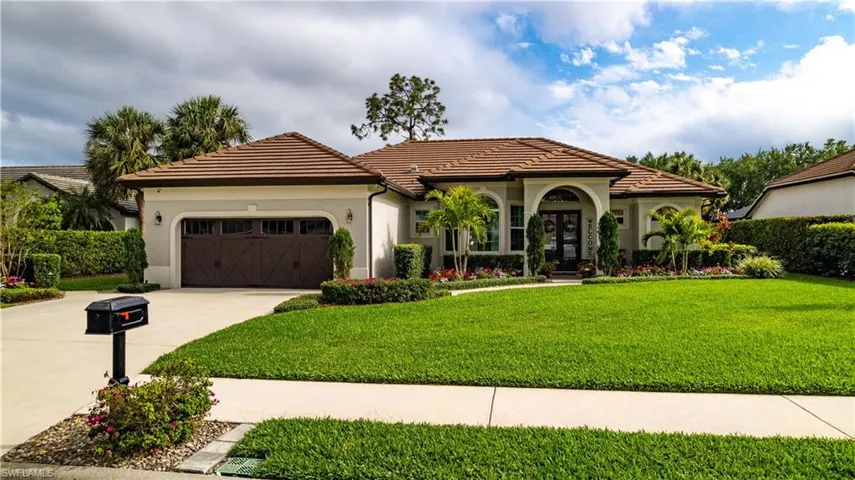 Mediterranean / spanish home featuring concrete driveway, a tiled roof, french doors, an attached garage, and a front yard