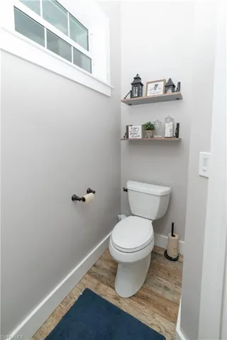Bathroom with baseboards, toilet, and wood finished floors