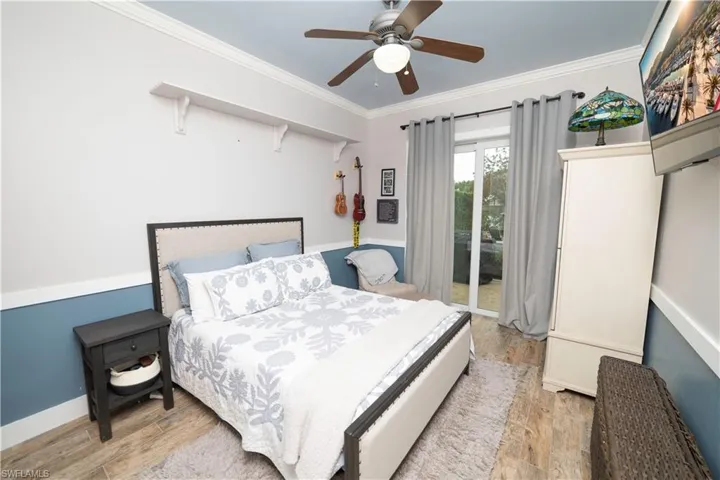Bedroom featuring ceiling fan, access to outside, light wood finished floors, baseboards, and ornamental molding