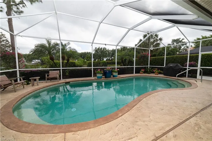 Outdoor pool with a lanai, area for grilling, and a patio
