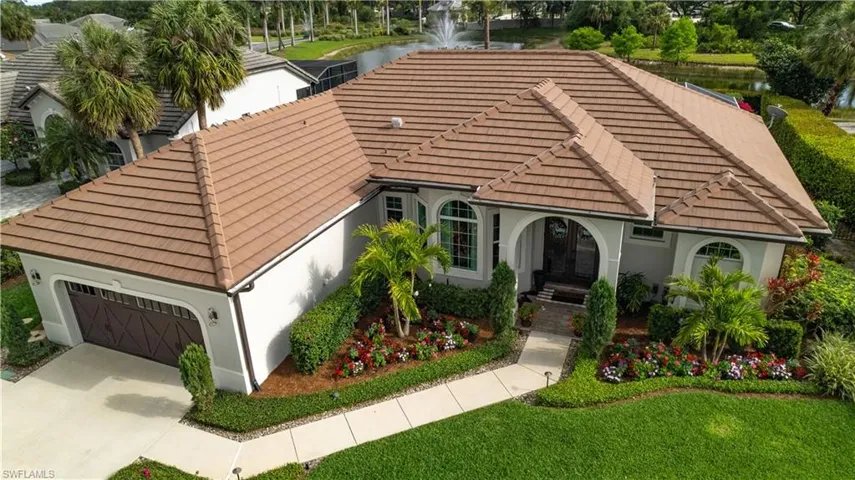 Mediterranean / spanish-style home with stucco siding, a water view, concrete driveway, and a tiled roof