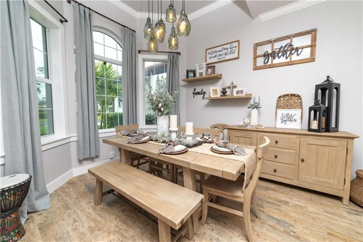 Dining room featuring light wood-type flooring, baseboards, and crown molding