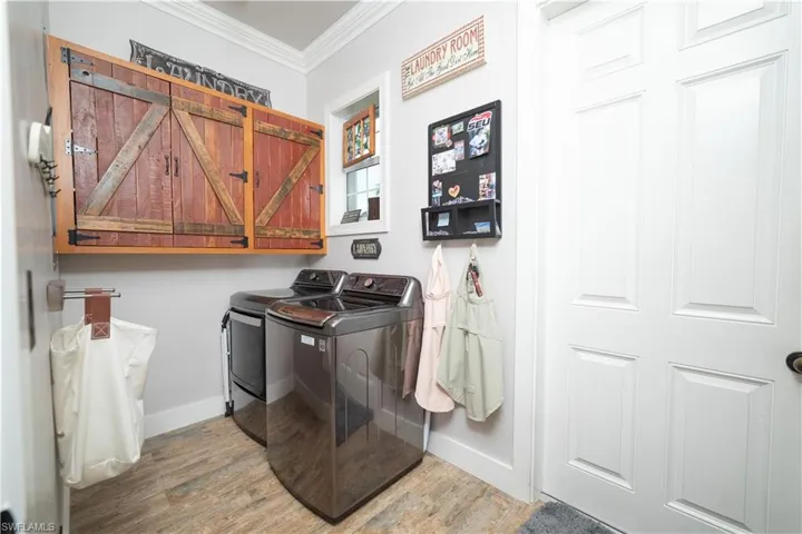 Laundry area featuring cabinet space, baseboards, crown molding, and independent washer and dryer