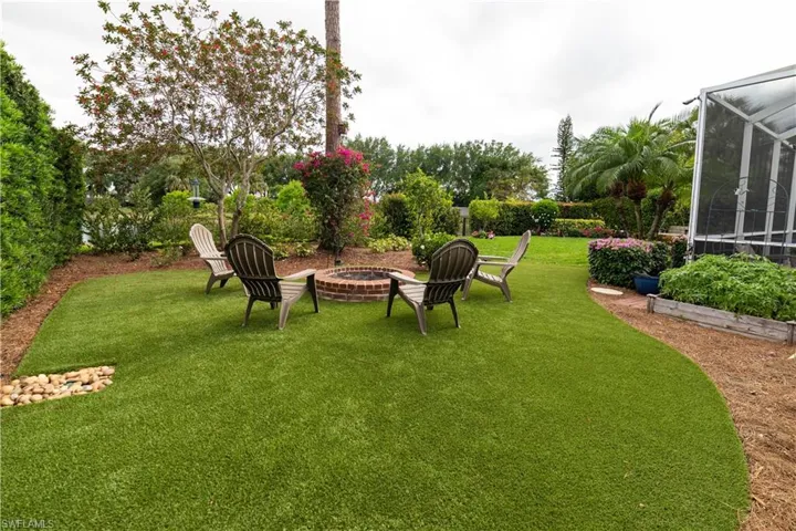 View of yard with glass enclosure and an outdoor fire pit
