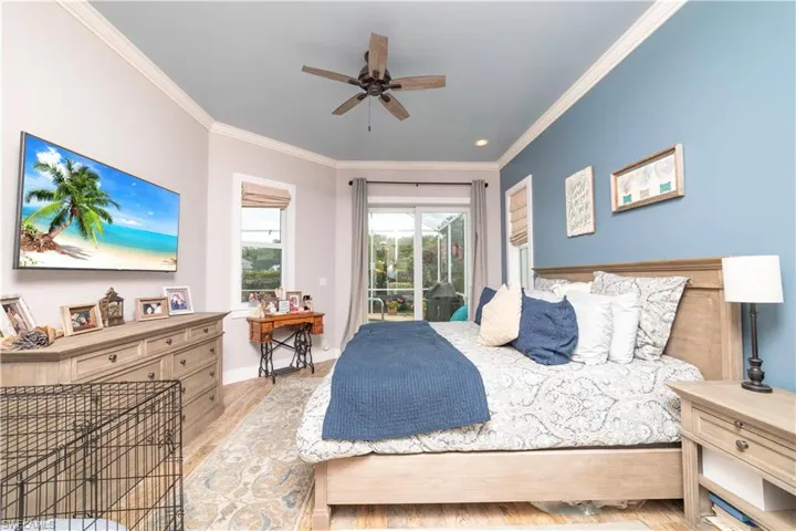 Bedroom with a ceiling fan, light wood-type flooring, access to outside, baseboards, and ornamental molding