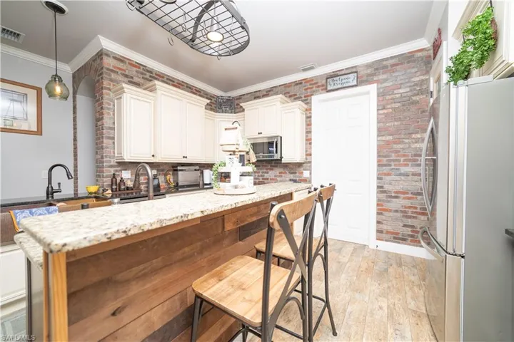 Kitchen with visible vents, a sink, appliances with stainless steel finishes, and crown molding