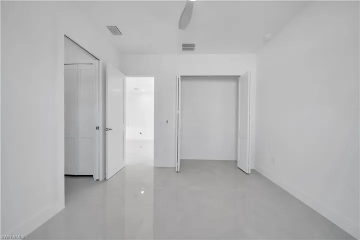 Unfurnished bedroom with concrete floors and ceiling fan