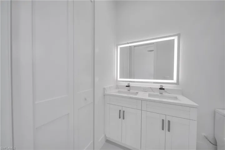 Bathroom featuring double vanity and a closet