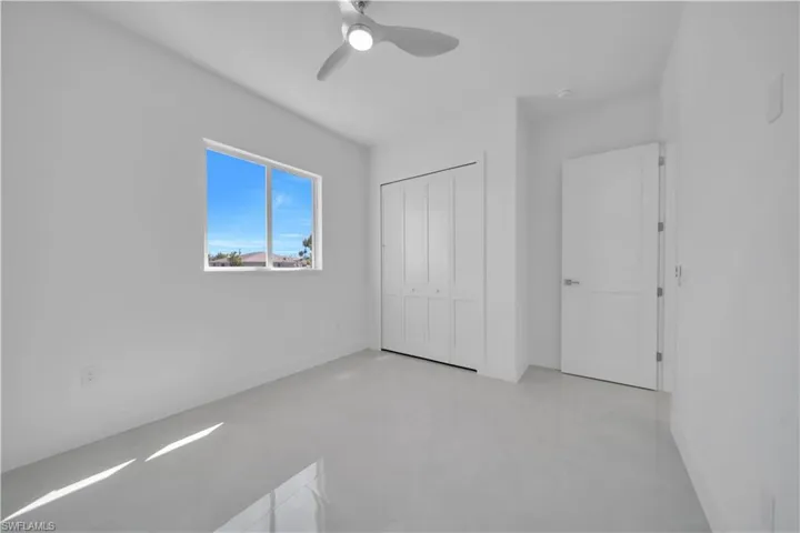 Unfurnished bedroom with concrete floors, a closet, and a ceiling fan