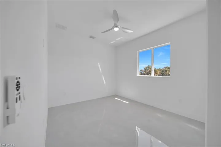 Spare room featuring concrete floors and ceiling fan