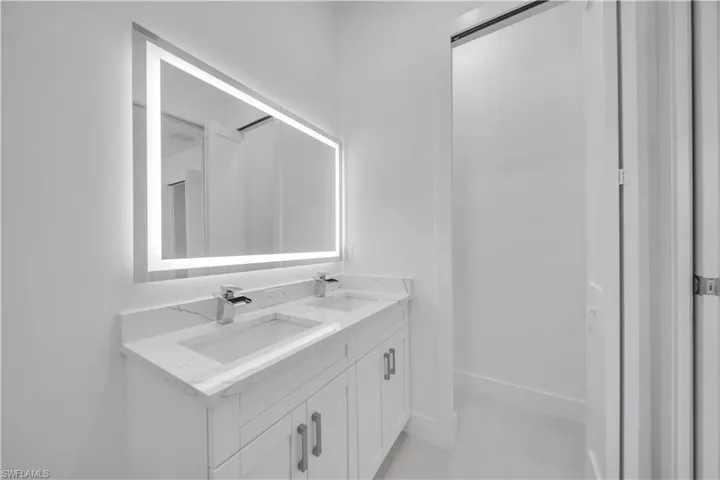 Bathroom featuring double vanity and baseboards