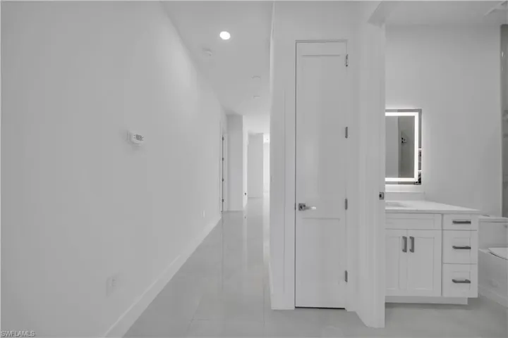 Hallway with baseboards and recessed lighting