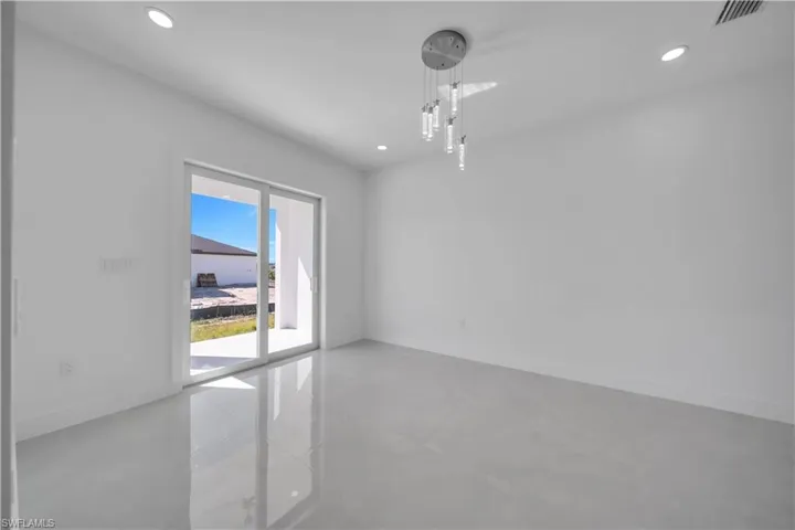 Empty room with finished concrete flooring and recessed lighting
