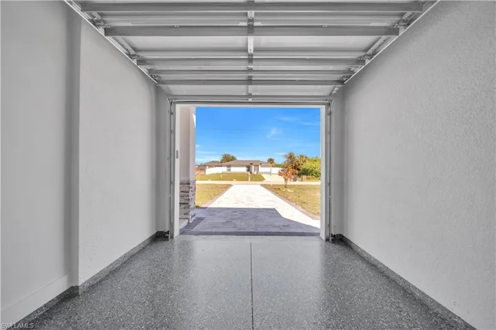 Garage with a textured wall and baseboards